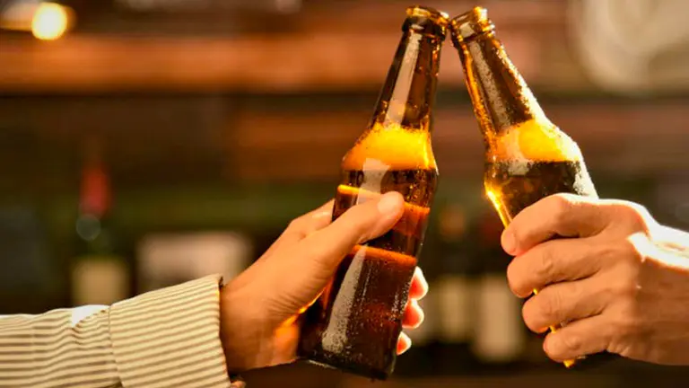 Un brindis con botellas de cerveza.