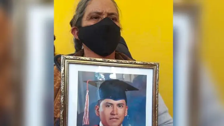 Mujer sostiene el cuadro de su hijo desaparecido y pide ayuda para encontrarlo. Radio San Simón