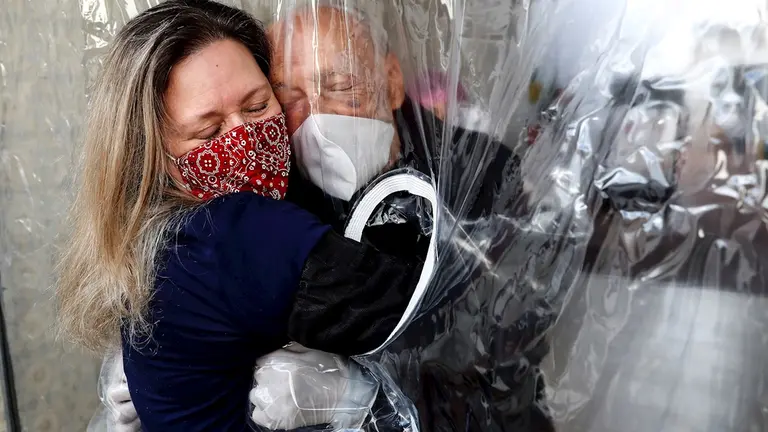 Mar&iacute;a Paula Moraes abraza su padre Wanderley de 82 a&ntilde;os, que vive en una residencia de ancianos en la ciudad de Sao Paulo (Brasil), a trav&eacute;s de una "cortina de abrazos". EFE