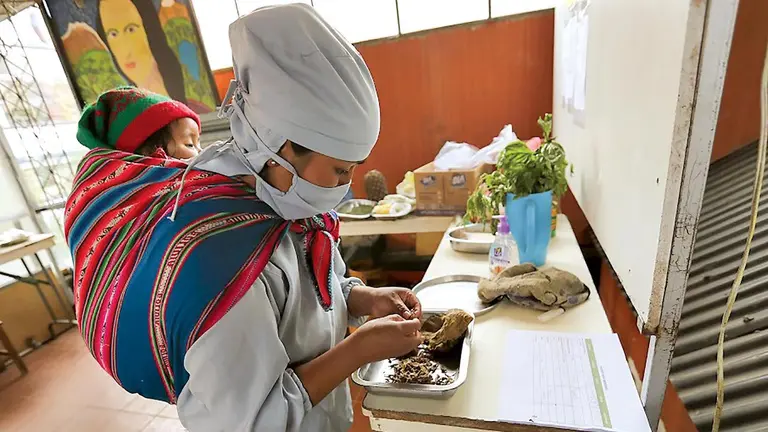 Una mujer emprendedora prepara pizzas con sello 100% boliviano.