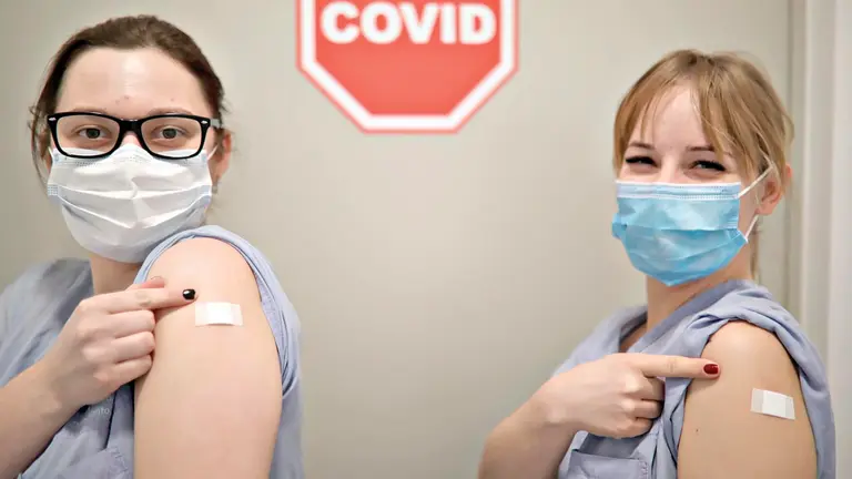 Dos sanitarias alientan a vacunarse en Polonia. EFE