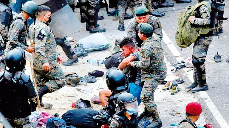 Soldados guatemaltecos arrastran a un hombre luego de golpear a migrantes  hondureños. EFE