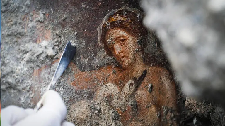 Una arque&oacute;loga trabaja en el fresco "Leda e il cigno" (Leda y el cisne), descubierto recientemente en el &aacute;rea "Regio V", del Parque Arqueol&oacute;gico de Pompeya. EFE