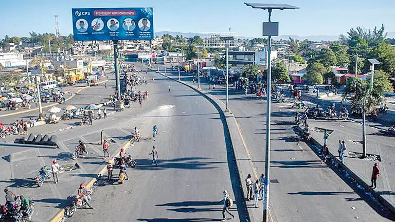 Transeúntes caminan por la falta de transporte durante una huelga general en Haití. EFE