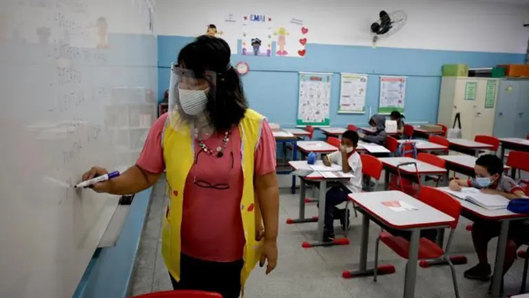 Fotograf&iacute;a referencial de una profesora dando clases con medidas de bioseguridad. EFE