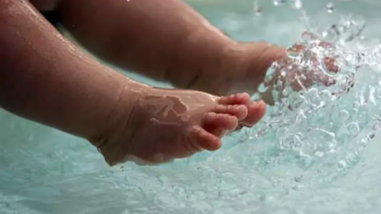 Fotograf&iacute;a ilustrativa de los pies de un ni&ntilde;o en el agua. URGENTE.