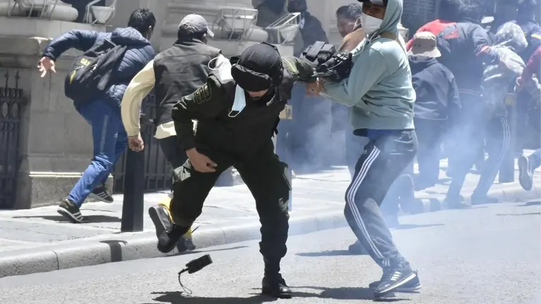 Uno de los manifestantes golpea a un polic&iacute;a, en La Paz. APG  policial.jpg