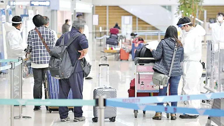 Personal del aeropuerto internacional de Incheon, al este de Seúl, revisan la PCR negativa de los recién llegados. EFE