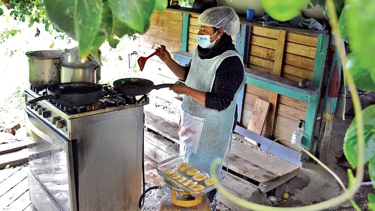 Una de las mujeres que sufrió violencia cocina  en las instalaciones de Adelante Mujer.  DICO SOLÍS