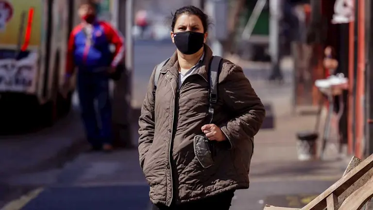 Fotograf&iacute;a que muestra una mujer con tapabocas mientras espera el transporte p&uacute;blico en la zona del mercado 4 de Asunci&oacute;n (Paraguay). EFE