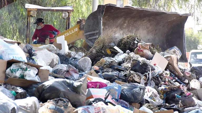 Un funcionario de EMSA recoge con maquinaria pesada la basura acumulada en la calle. DICO SOLÍS