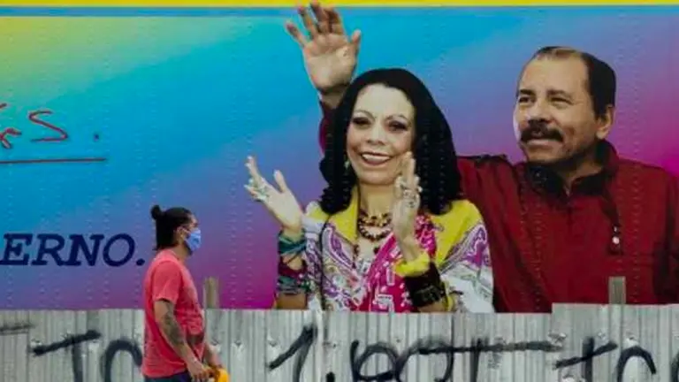 Un hombre con tapabocas, como medida de prevención ante el coronavirus, pasa frente a un aviso del presidente de Nicaragua Daniel Ortega (d) y su esposa Rosario Murillo. EFE