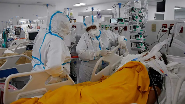 Dos enfermeras atienden a un paciente en la Unidad de Cuidados Intensivos para pacientes covid-19 del Hospital El Salvador, en San Salvador (El Salvador). EFE