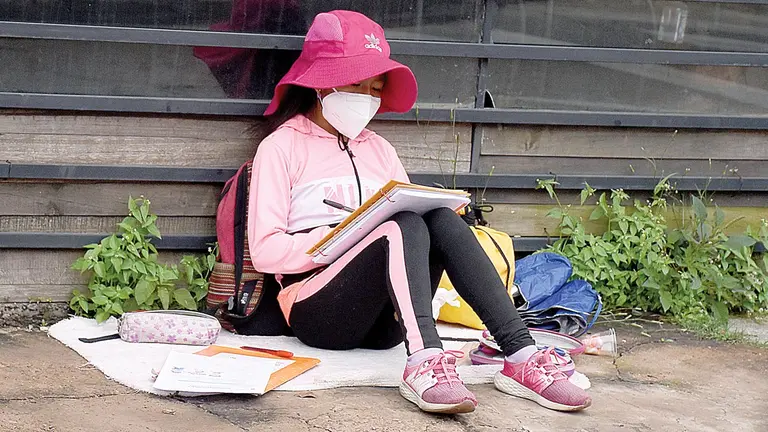 Una niña hace tareas cerca de la avenida Humboldt, mientras sus padres venden caramelos.    DICO SOLÍS
