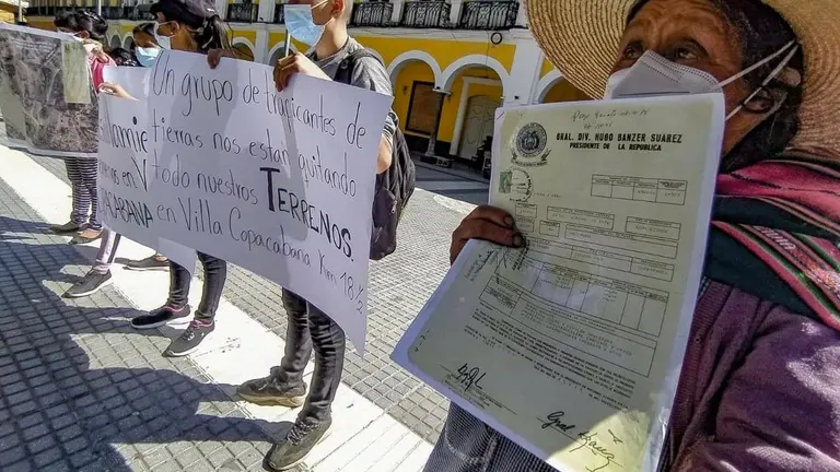 Vecinos de Villa Copacabana presentan títulos de propiedad y carteles de protesta en la plaza 14 de Septiembre. DICO SOLÍS