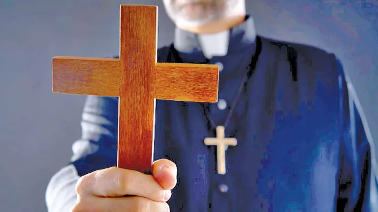 Un sacerdote de la Iglesia Católica sostiene una cruz. ARCHIVO