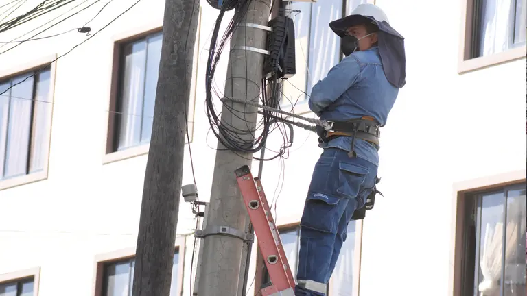 Un trabajador de ELFEC realiza trabajos en un poste de energía. ARCHIVO