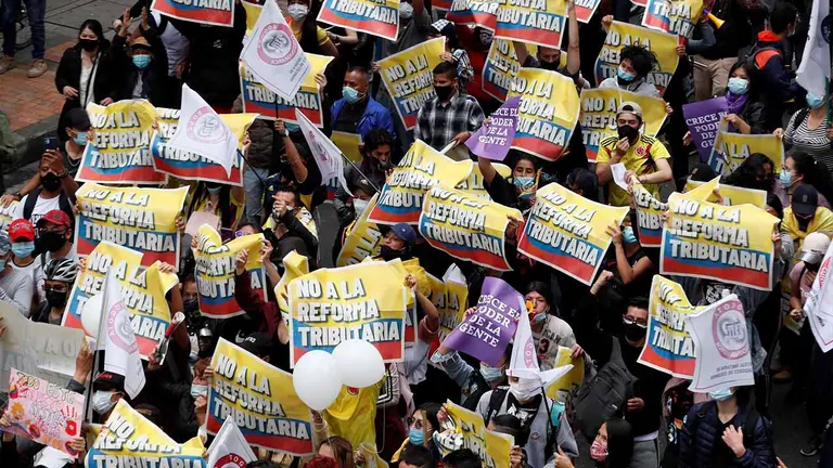Decenas de personas entre las que sobresalen carteles de protesta participa en la jornada de manifestaciones denominada Paro Nacional, convocada en todo el pa&iacute;s para rechazar, entre otros, la reforma tributaria del Gobierno hoy, en Bogot&aacute; (Colombia). EFE