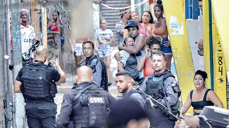 Habitantes de una favela observan a miembros de la Policía que realizan un operativo policial. EFE