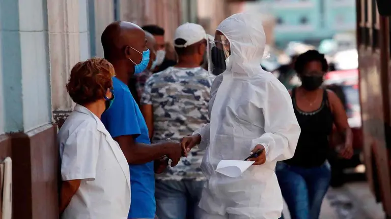 Una trabajadora de la salud habla con varias personas en La Habana. EFE