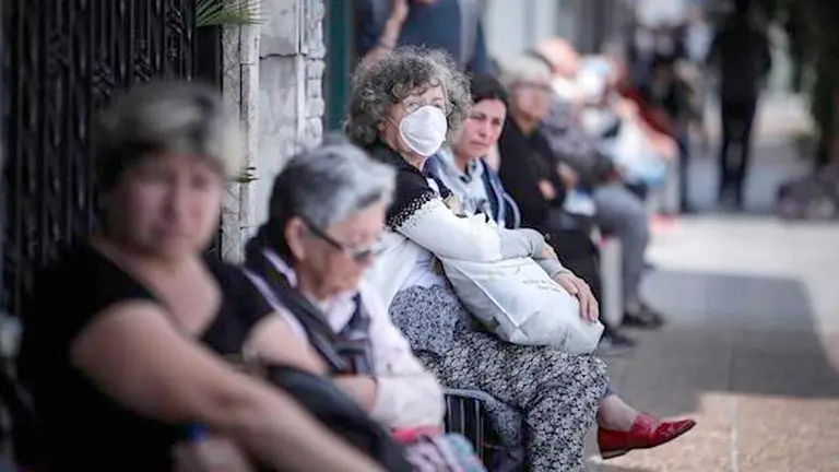 Personas que hacen fila afuera de un banco donde pagan jubilaciones y planes sociales en Buenos Aires (Argentina). EFE