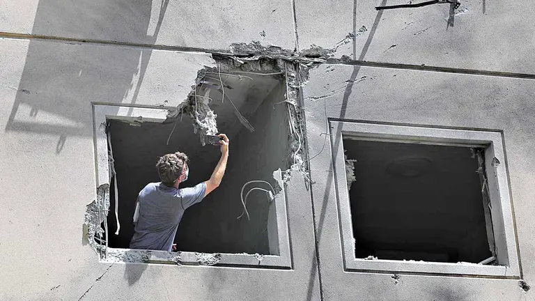 Un inspector trabaja en un apartamento dañado por un cohete disparado por Israel hacia la franja de Gaza. EFE