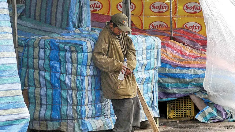 Una persona en situación de calle descansa en un mercado de Cochabamba. DICO SOLÍS