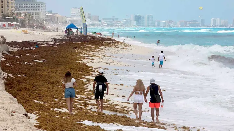 Varias personas caminan por la playa, en el balneario de Cancún, México. EFE