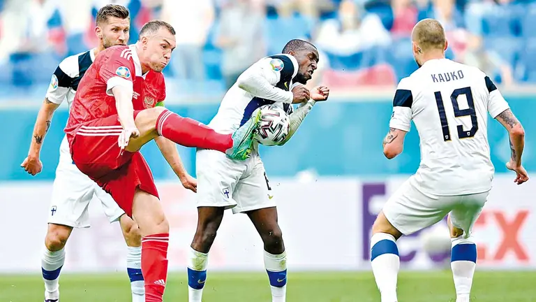 Artem Dzyuba (i) de Rusia ensaya un disparo ante la marca de Glen Kamara (c) de Finlandia. EFE