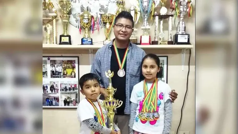 La representante en el Mundial de Ajedrez, Marizol Escobar, junto a su hermano Diego y su entrenador Mauricio Colque, fundador de ANBA. Cortes&iacute;a Mauricio Colque