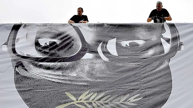 Equipo de logística cuelga el póster oficial de la edición 74 de Cannes.  EFE