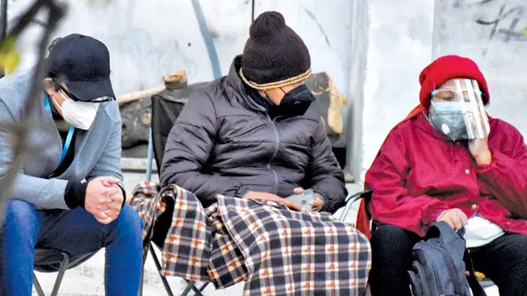 Dos personas se protegen del frío con ropa abrigada y mantas. DICO SOLÍS
