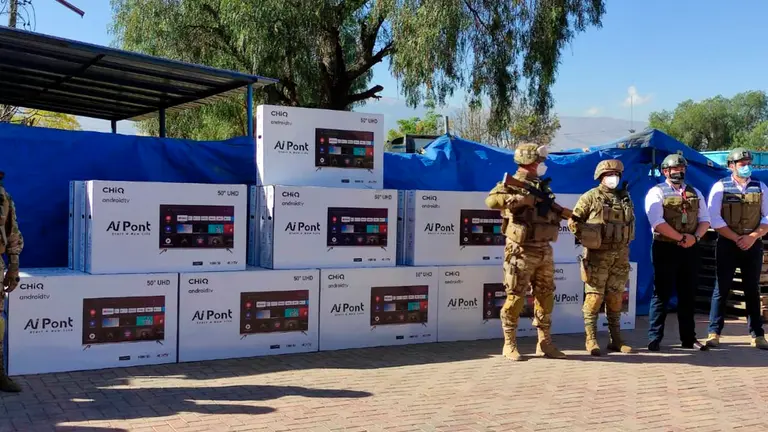 Efectivos de la Aduana Nacional exhibiendo los televisores comisados. Aduana