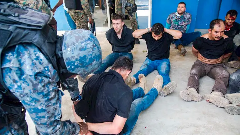 Policías custodian hoy a un grupo de sospechosos de haber participado en el asesinato del presidente haitiano, Jovenel Moise, en Puerto Príncipe (Haití). EFE