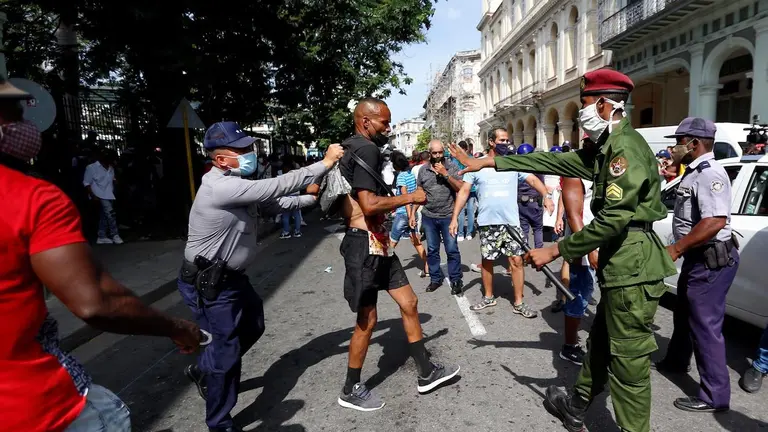 Polic&iacute;as arrestan a un hombre cuando personas se manifiestan hoy, en una calle en La Habana (Cuba). EFE