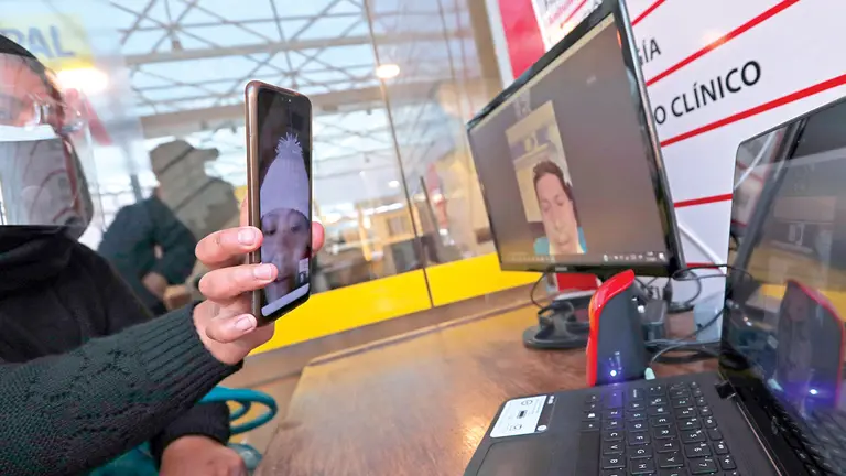 Una mujer se conecta con su familiar y con un celular le permite ver a otro ser querido.	          EFE