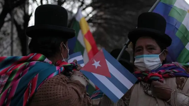 Mujeres, movilizadas con banderines de Cuba y wiphalas. APG