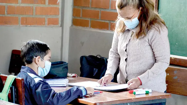 Una maestra revisa la tarea de un niño del nivel primario. DICO SOLÍS