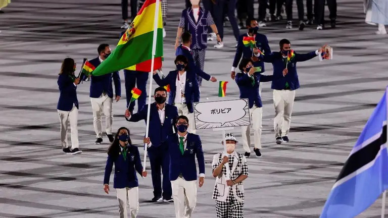 Karen Tórrez y Gabriel Castillo llevan la bandera nacional con el resto del Equipo Bolivia, durante la ceremonia inaugural de los Juegos Olímpicos de Tokio. EFE