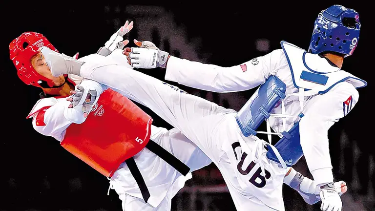 El cubano Rafael Yunier Alba Castillo (azul) durante el encuentro por el bronce. EFE