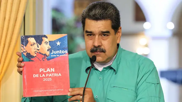 El presidente Nicol&aacute;s Maduro, muestra el libre "Plan de la Patria" durante una jornada para fortalecimiento de la agroindustria nacional en el Palacio de Miraflores en Caracas. EFE