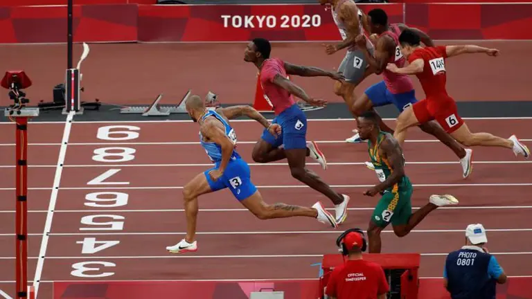 Lamont Marcell Jacobs (i) de Italia cruza la meta para ganar la final de los 100 metros. EFE