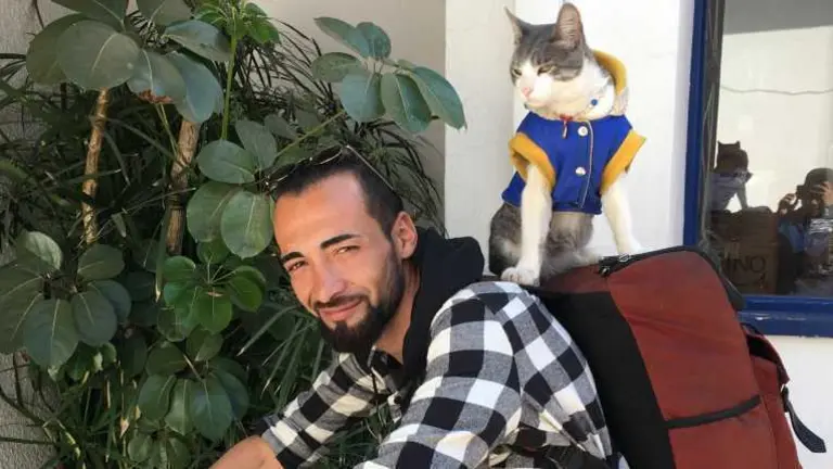 Bella y Jhon, el gato y el mochilero colombiano, durante una visita a las instalaciones del peri&oacute;dico OPINI&Oacute;N.