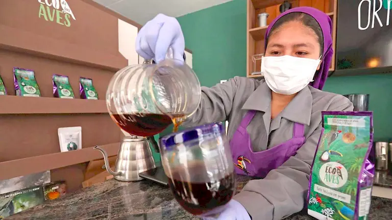 Fotografía fechada el 5 de agosto de 2021 que muestra a la barista Sandra Alcón mientras sirve un café en la tienda cafetería Origen Eco de las Aves en La Paz. EFE