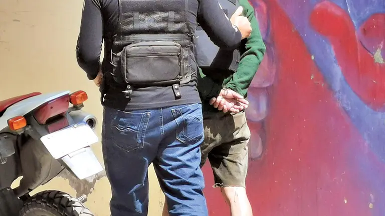 Fotografía ilustrativa de un aprehendido siendo trasladado a celdas policiales. 
