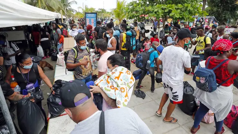 Imagen de archivo de migrantes de diversas partes del mundo comprando tiquetes para Capurganá, en el embarcadero de Necoclí (Colombia). EFE