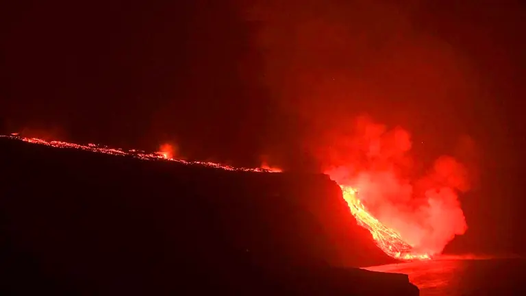 La colada de lava que emerge de la erupción volcánica de La Palma ha llegado esta noche al mar en una zona de acantilados situados en las cercanías de la playa El Guirre, en Tazacorte. EFE