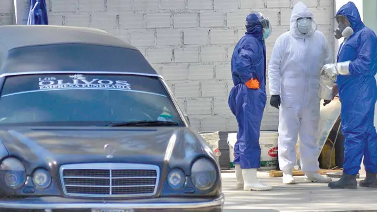 Personal de la morgue aguarda la cremación de un cadáver que fue transportado por un carro fúnebre. NOÉ PORTUGAL