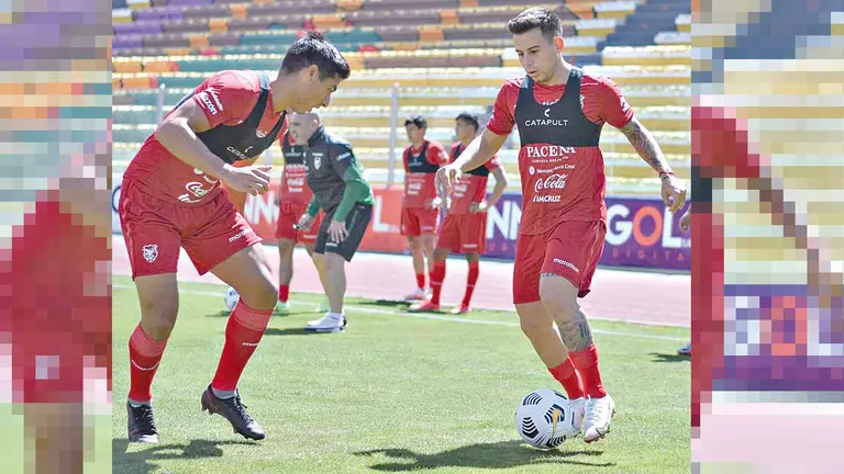 El atacante de Bolivia Henry Vaca (d) domina la pelota ante la marca de su compañero. FBF