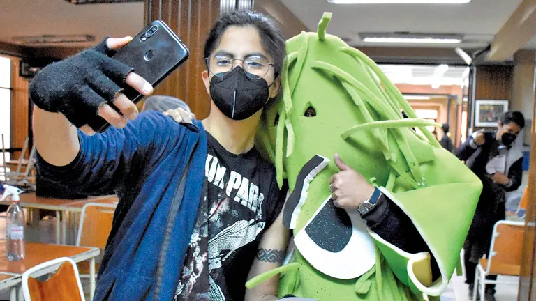 Un joven se toma una fotografía con un personaje COVID. DICO SOLÍS